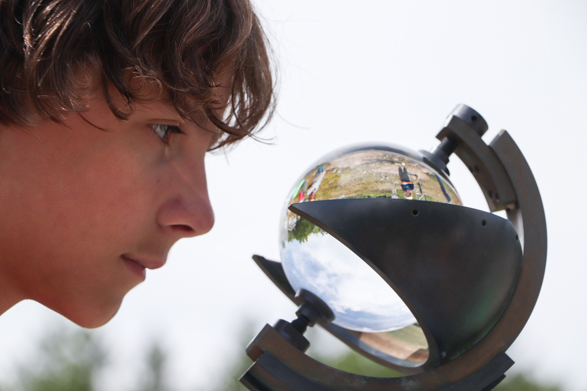 Young boy looks at a transparent sphere